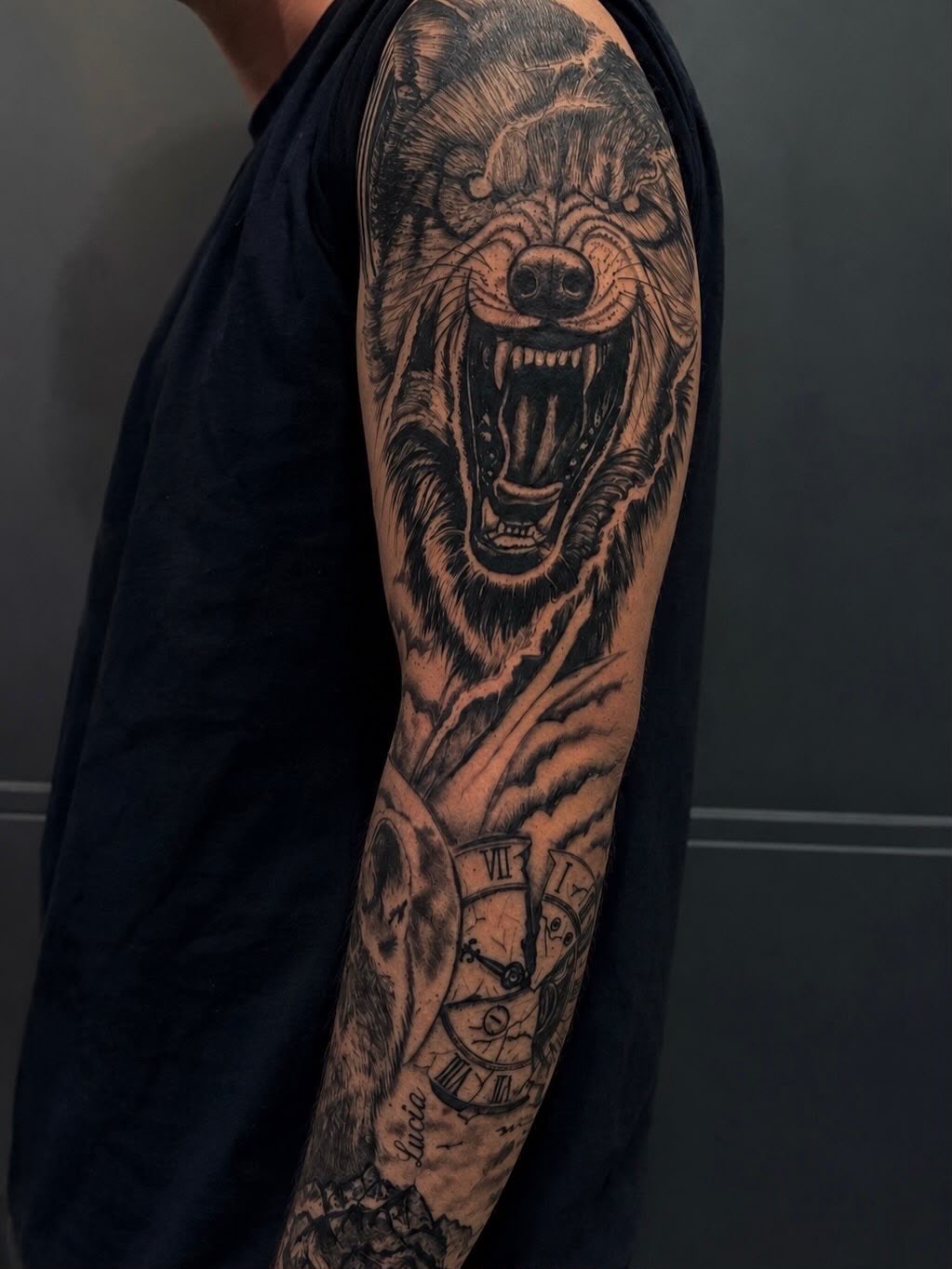 Tatuaje blackwork de oso y reloj en manga completa