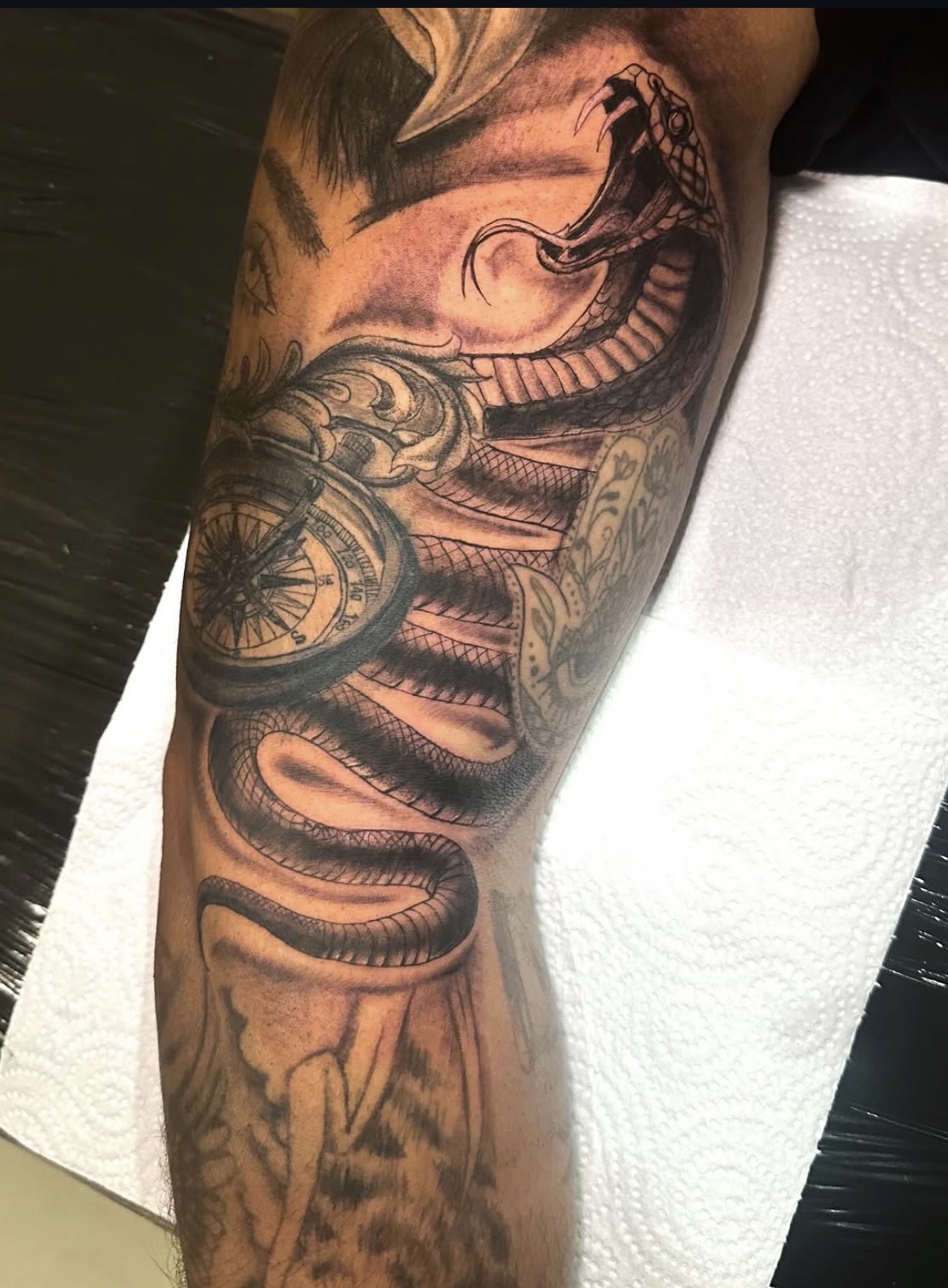 Tatuaje personalizado de serpiente y brújula en brazo